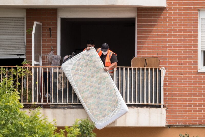 Los bajos datos de okupación contrastan con la preocupación de los canarios. En la imagen, un trabajador saca un colchón por el balcón durante el desalojo de una vivienda.