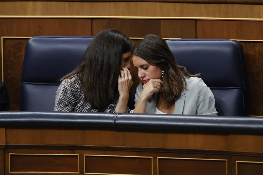 La ministra de Igualdad en funciones, Irene Montero (d) conversa con la ministra de Derechos Sociales y Agenda 2030 en funciones, Ione Belarra (i) durante la primera sesión del debate de investidura del candidato Alberto Núñez Feijóo, este martes en el Congreso. EFE/Juan Carlos Hidalgo