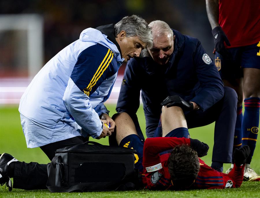 El centrocampista de la selección española Gavi es atendido en el terreno de juego por el equipo médico