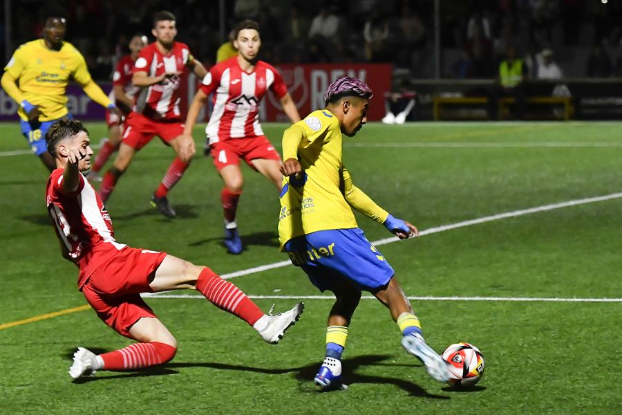 El defensa mexicano de la UD Las Palmas Julián Araujo (d) dispara para conseguir el primer gol del equipo canario ante el CD Manacor, durante el encuentro correspondiente a la primera eliminatoria de la Copa del Rey que se disputa hoy martes en el estadio Na Capelleirra de la localidad balear. EFE/MIQUEL A. BORRÀS