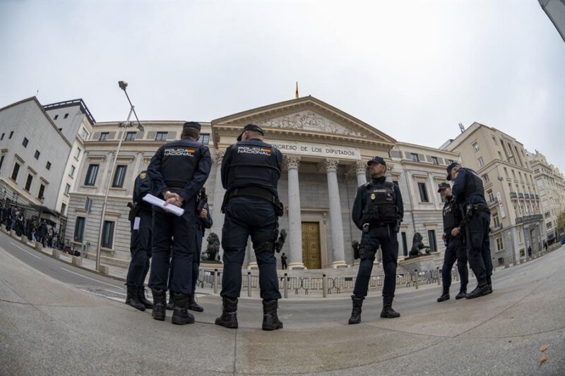 Policías desplegados en los alrededores del Congreso de los Diputados antes de la celebración del primer día del debate de investidura del líder del PSOE, Pedro Sánchez, que expondrá su nuevo programa de Gobierno y pedirá la confianza a la Cámara para revalidar su mandato en la Moncloa, este miércoles, en Madrid. EFE/Fernando Villar