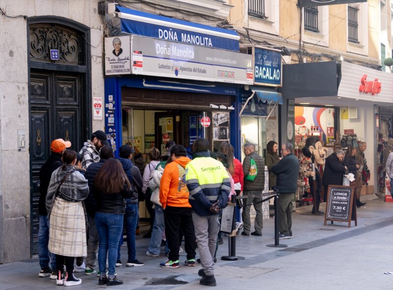 Varias personas hacen cola para comprar décimos de cara al Sorteo Extraordinario de la Lotería de Navidad, en la Administración de Loterías Doña Manolita, a 14 de diciembre de 2023, en Madrid (España). El establecimiento fue inaugurado por Manuela de Pablo en 1904, y desde entonces se ha convertido en un lugar al que cada año acuden miles de personas para comprar uno o varios décimos para el próximo Sorteo Extraordinario de Navidad, que se celebra el próximo 22 de diciembre. Con el sorteo, el Estado reparte 2.520 millones de euros en premios entre los 180 millones de décimos emitidos. El tiempo de espera de la cola para adquirir la lotería en Doña Manolita durante el mes de diciembre puede llegar a las tres horas. 14 DICIEMBRE 2023 / Eduardo Parra / Europa Press 14/12/2023