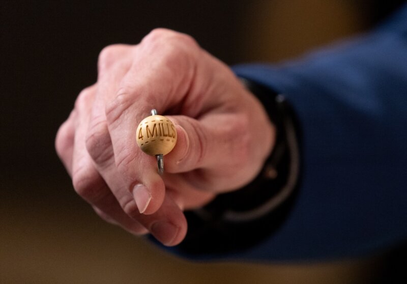 Un hombre enseña una bola con la cantidad de dinero de uno de los premios al inicio del Sorteo Extraordinario de la Lotería de Navidad 2023 en el Teatro Real de Madrid, a 22 de diciembre de 2023, en Madrid (España).  Eduardo Parra / Europa Press 22/12/2023