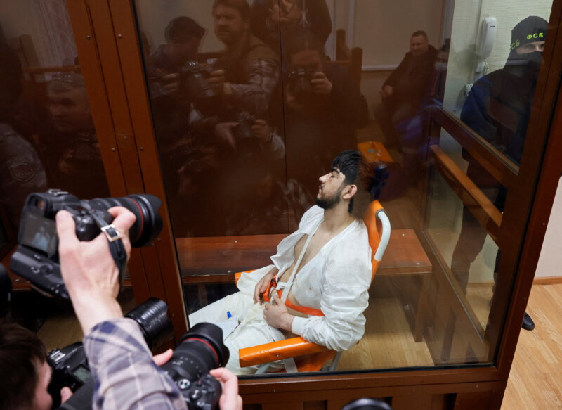 Muhammadsobir Fayzov, sospechoso del ataque a tiros en la sala de conciertos Crocus City Hall, se sienta en una silla de transporte médico detrás de un cristal en un recinto para los acusados antes de una audiencia judicial en el tribunal de distrito de Basmanny en Moscú, Rusia, el 25 de marzo de 2024. REUTERS/Shamil Zhumatov
