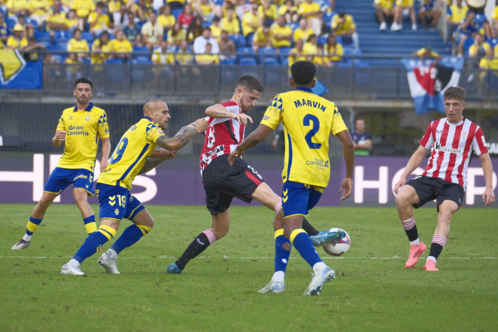 El delantero de la UD Las Palmas Sandro Ramírez (i) disputa un balón con el centrocampista Oihan Sancet del Athletic de Bilbao, durante el encuentro de la quinta jornada de LaLiga que UD Las Palmas y Athletic de Bilbao disputan hoy domingo en el estadio de Gran Canaria. EFE/Ángel Medina G.