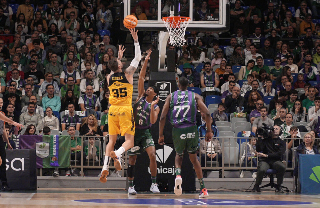Fran Guerra tira a canasta ante dos defensores del Unicaja