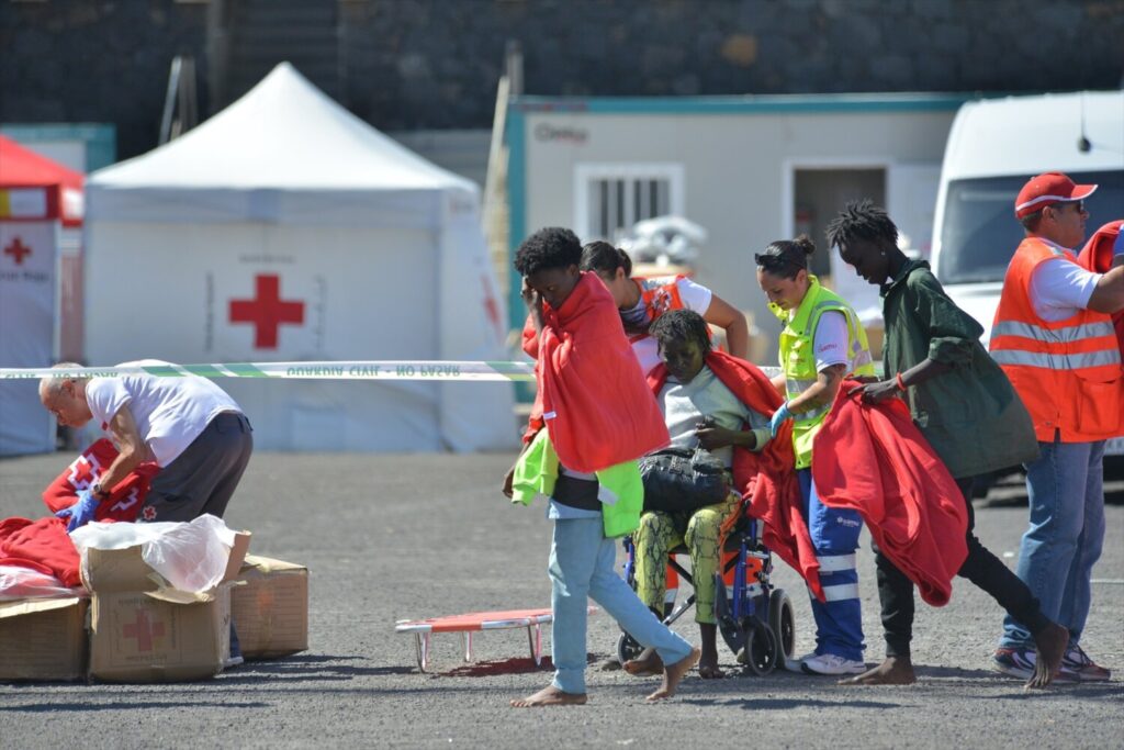 Foto de archivo de miembros de Cruz Roja atendiendo a migrantes tras la llegada de una patera al muelle de La Restinga