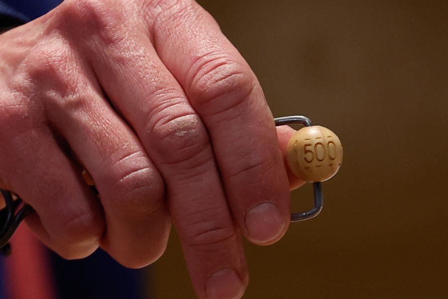 Un responsable enseña la bola de 500.000 euros, el tercer premio, antes de ser introducida en su respectivo bombo durante preparativos para el sorteo de la Lotería de Navidad este domingo en el Teatro Real, en Madrid. EFE/Javier Lizón