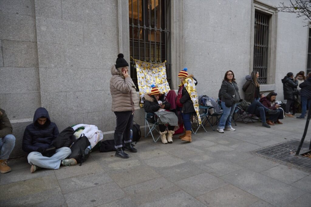 Varias personas hacen cola para entrar en el Sorteo Extraordinario de la Lotería de Navidad, en el Teatro Real en la tarde de este sábado en Madrid / Europa Press