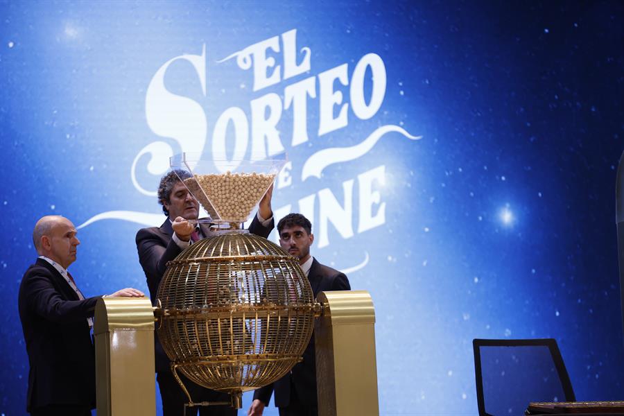 Varios responsables introducen las bolas de los premios en su correspondiente bombo durante preparativos para el sorteo de la Lotería de Navidad este domingo en el Teatro Real, en Madrid. EFE/Javier Lizón