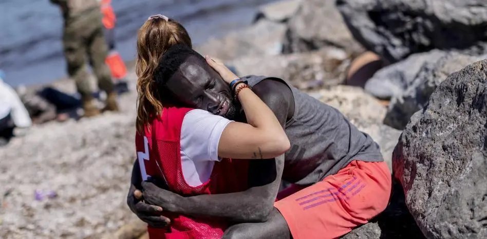 Fotografía de Abdou Ngom y Luna Reyes, migrante senegalés y voluntaria de Cruz Roja, que se convirtieron en símbolo de empatía y humanidad con la situación de los migrantes Imagen: Bernat Armangue/AP Photo/picture alliance
