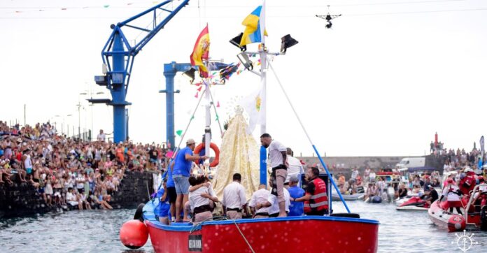 La Virgen del Carmen es subida a la embarcación antes de dar comienzo la procesión marinera en el Puerto de la Cruz