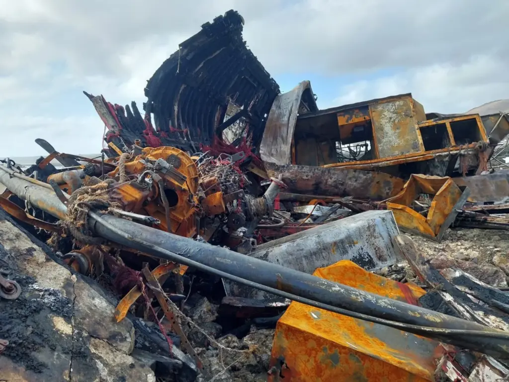 Estado en el que quedó el barco atunero encallado en Órzola tras el incendio