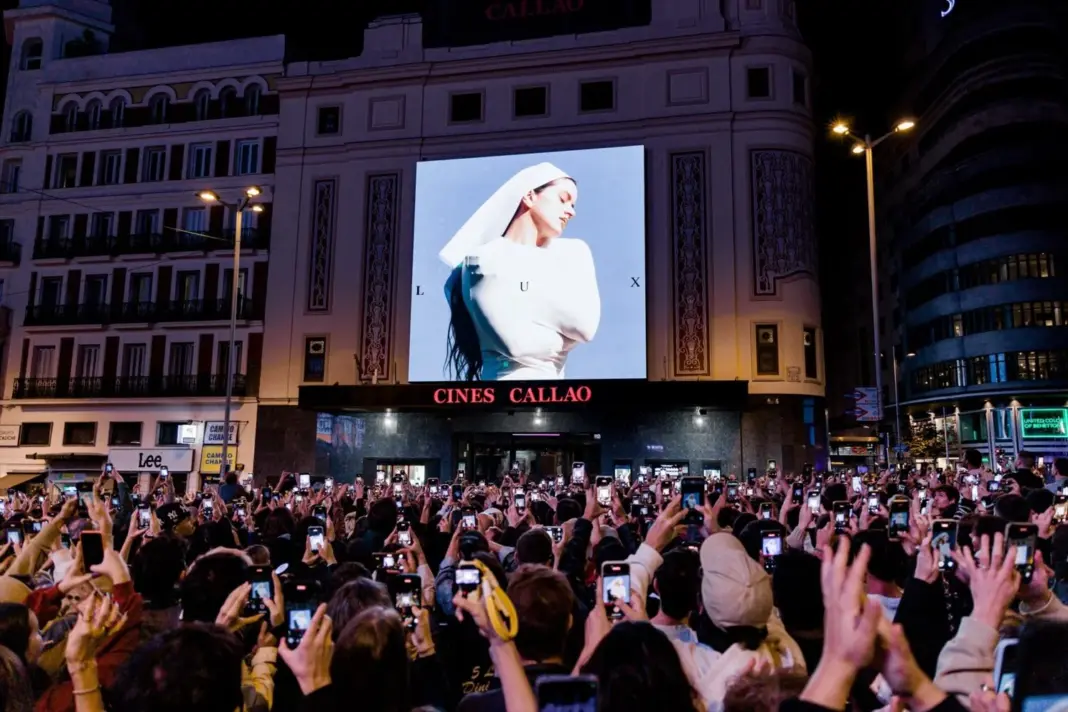 Decenas de personas observan la portada del nuevo álbum de Rosalía, 'Lux', en la plaza de Callao, en Madrid, el pasado 20 de octubre de 2025 | Carlos Luján / Europa Press