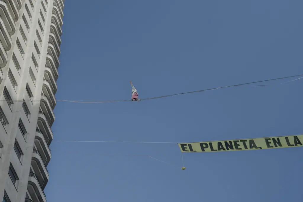 Una activista de Greenpeace camina por una cuerda floja sobre el centro de Madrid para exigir fin de los combustibles fósiles