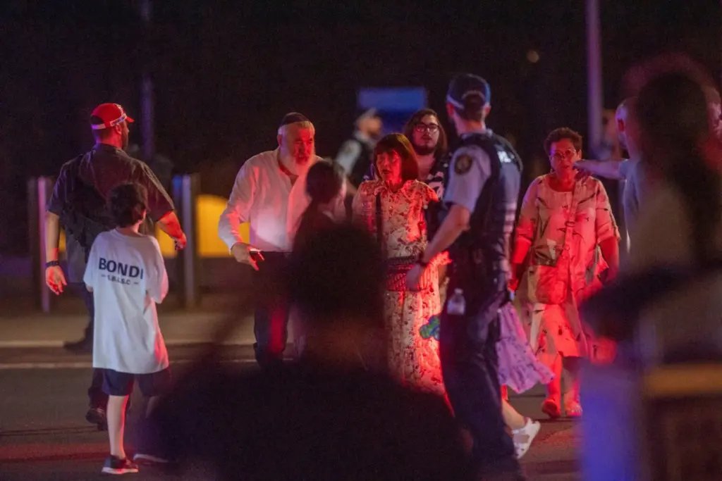 La gente camina mientras agentes de policía montan guardia en la calle tras un tiroteo en Bondi Beach, Sídney, Australia, el 14 de diciembre de 2025. AAP/Jeremy Piper /vía REUTERS.