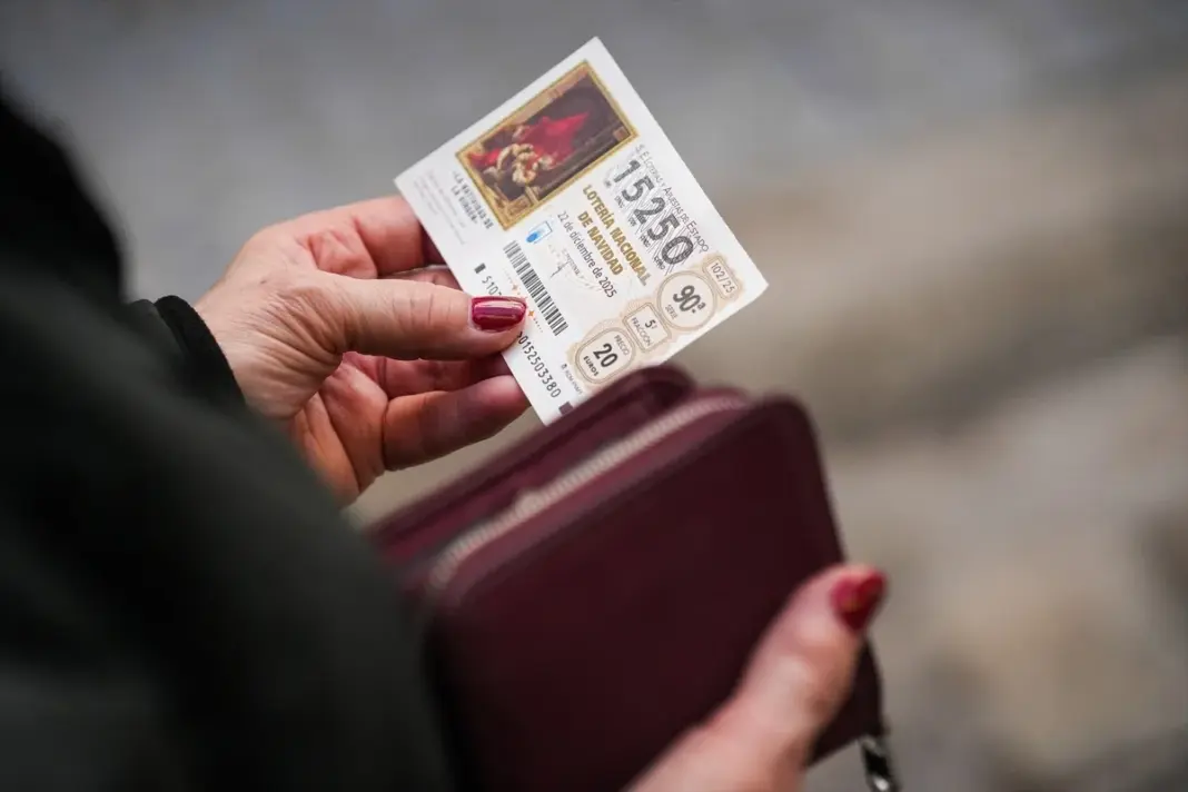 Una mujer sostiene un décimo de la Lotería de Navidad 2025 / RTVC