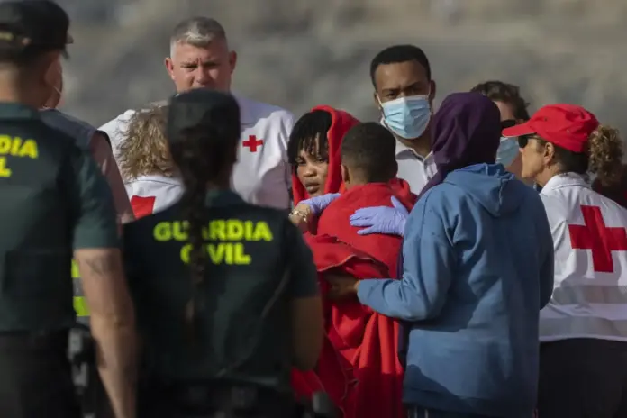 Una mujer con un niño en brazo tras la llegada de una embarcación. EFE