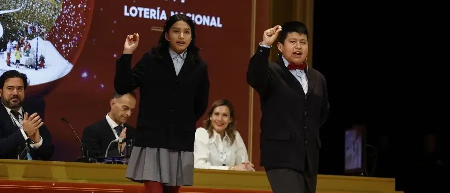 Aisha Solange (i) y Gorka Calderón (d), cantan un cuarto premio, el 78.477, que ha sido agraciado con un cuarto premio en el Sorteo de la Lotería de Navidad y dotado con 200.000 euros a la serie (20.000 euros al décimo). EFE/Chema Moya