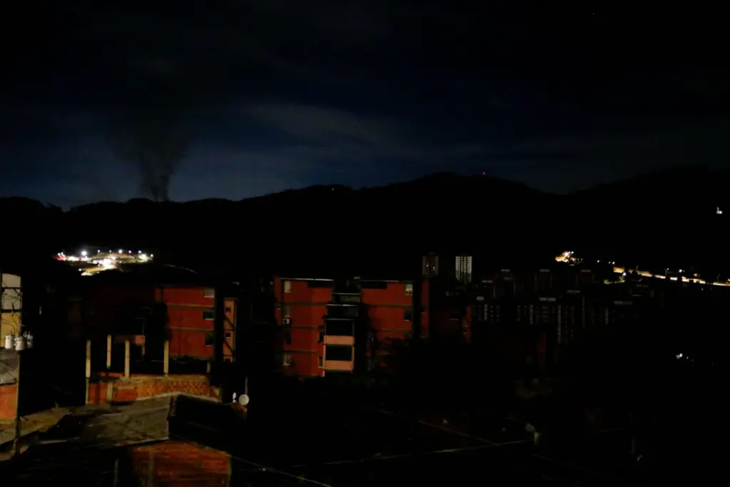 El humo se eleva cerca del Fuerte Tiuna durante un apagón total, tras explosiones y ruidos fuertes, en medio de las crecientes tensiones entre las administraciones del presidente estadounidense Donald Trump y el presidente venezolano Nicolás Maduro, en Caracas, Venezuela, el 3 de enero de 2026. REUTERS/Leonardo Fernández Viloria