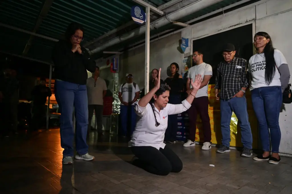 Familiares rezan mientras la gente se reúne afuera de la cárcel de El Rodeo después de que el presidente de la Asamblea Nacional de Venezuela, Jorge Rodríguez, anunciara que un número significativo de presos extranjeros y venezolanos serán liberados, en El Rodeo, estado Miranda, Venezuela, el 9 de enero de 2026. REUTERS/Gaby Oraa