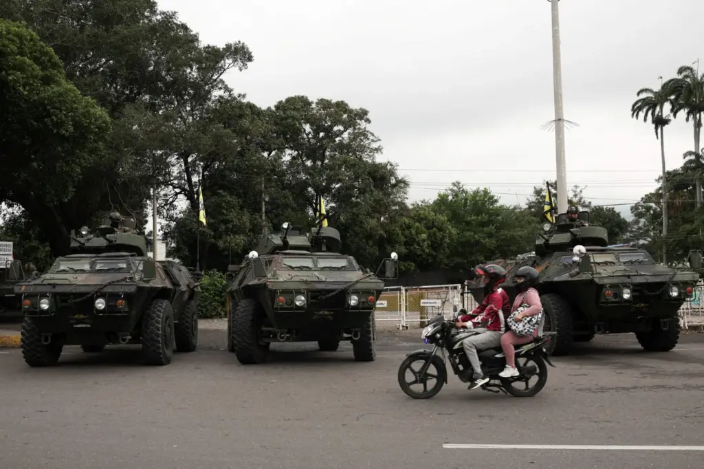 La gente viaja en una motocicleta junto a vehículos militares mientras soldados colombianos patrullan la frontera entre Venezuela y Colombia, después de que el presidente de Estados Unidos, Donald Trump, dijera que Estados Unidos atacó a Venezuela y capturó a su presidente Nicolás Maduro, en Cúcuta, Colombia, el 3 de enero de 2026. REUTERS/Luisa Gonzalez