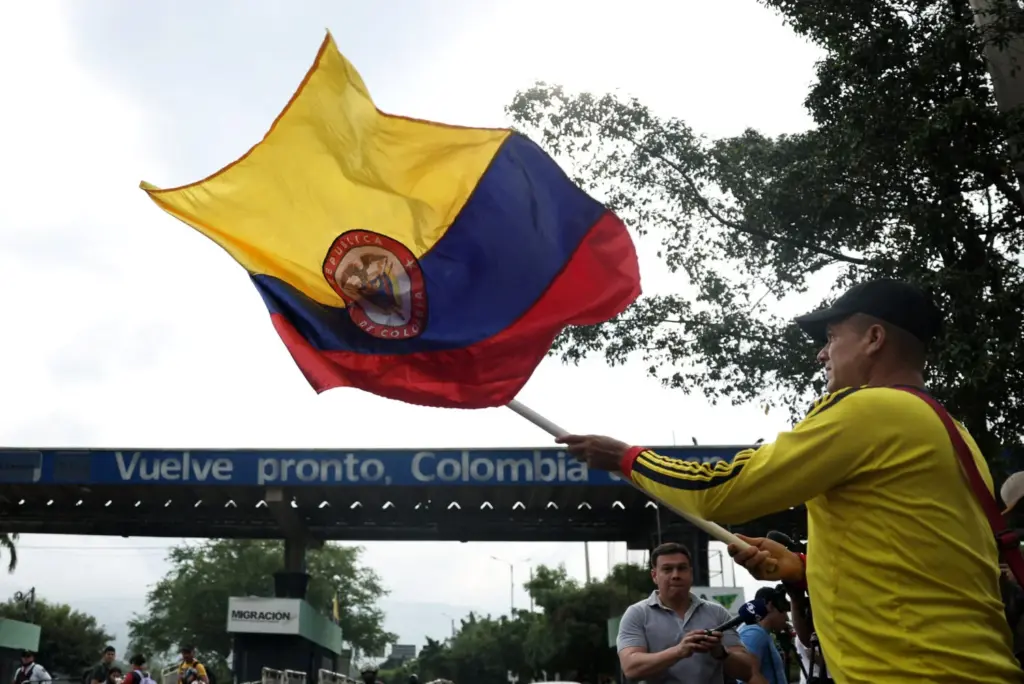 Una persona ondea una bandera con el escudo de armas de Colombia, en la frontera entre Venezuela y Colombia, después de que el presidente de Estados Unidos, Donald Trump, dijera que Estados Unidos atacó a Venezuela y capturó a su presidente, Nicolás Maduro, en Cúcuta, Colombia, el 3 de enero de 2026. REUTERS/Luisa Gonzalez