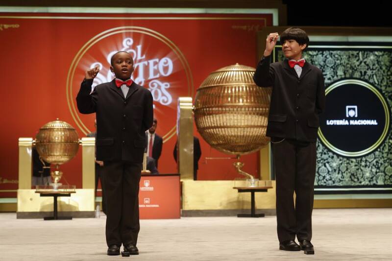  Los estudiantes de San Ildefonso Alonso Dávalos Durán (d) y su compañero Ángel Abaga Elebiyo (i) cantan el premio Gordo durante el sorteo de Navidad en el Teatro Real en Madrid, este jueves. EFE/ Javier Lizón
