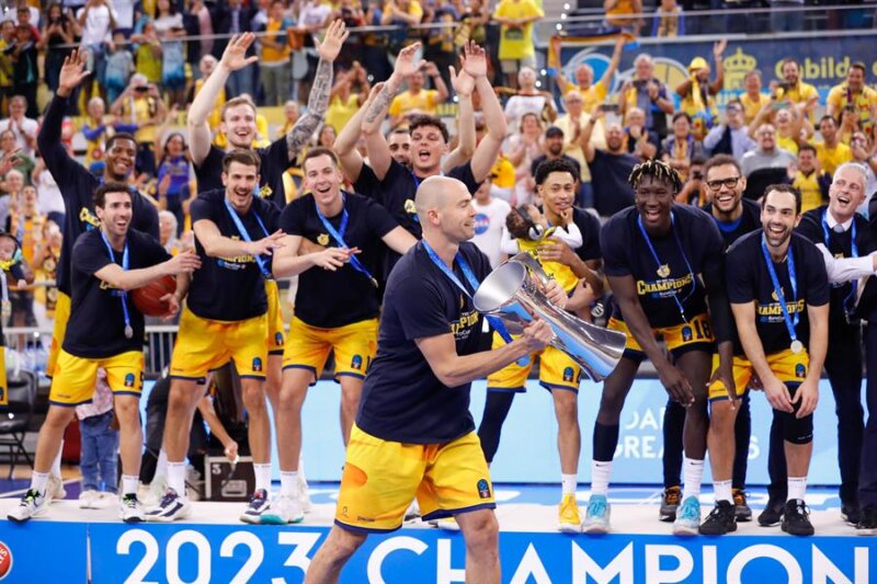 LAS PALMAS DE GRAN CANARIA, 03/05/2023.- Los jugadores y técnicos del Gran Canaria celebran que el equipo se ha proclamado este miércoles campeón de la Eurocopa de baloncesto por primera vez en su historia en una final épica y agónica frente al Turk Telekom de Ankara, que apretó hasta el final en el Arena, pero que terminó capitulando ante la solidez de su rival en los momentos claves de una noche mágica para el club claretiano (71-67). EFE/ Elvira Urquijo A.