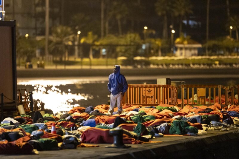 Unos 200 migrantes que llegaron en la tarde noche del viernes a Tenerife en dos cayucos han dormido en el muelle de Los Cristianos ante la falta de espacio en los centros de acogida, tras un pico de llegadas sin precedentes desde 2020 (unas 1.000 personas en un día) que obligó a esa derivar a esa isla a cientos desde El Hierro. EFE/Miguel Barreto