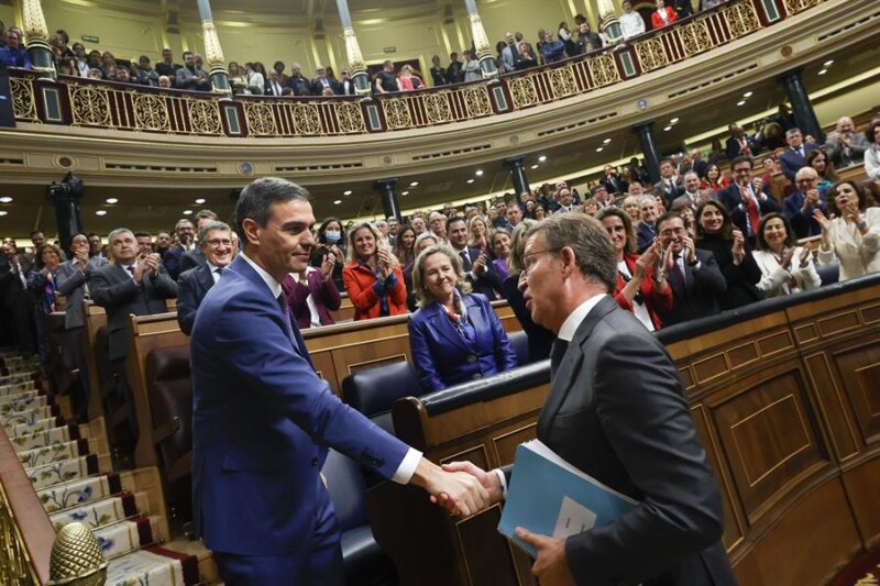 El líder del PP, Alberto Núñez Feijóo (d), felicita al presidente del Gobierno en funciones, Pedro Sánchez, al término de la segunda jornada del debate de investidura, este jueves en el Congreso de los Diputados en Madrid. Sánchez ha sido reelegido tras ser votado por 179 diputados tras pactar diferentes acuerdos con sus socios parlamentarios y una ley de amnistía para los encausados del 'procès'. EFE/ Javier Lizón