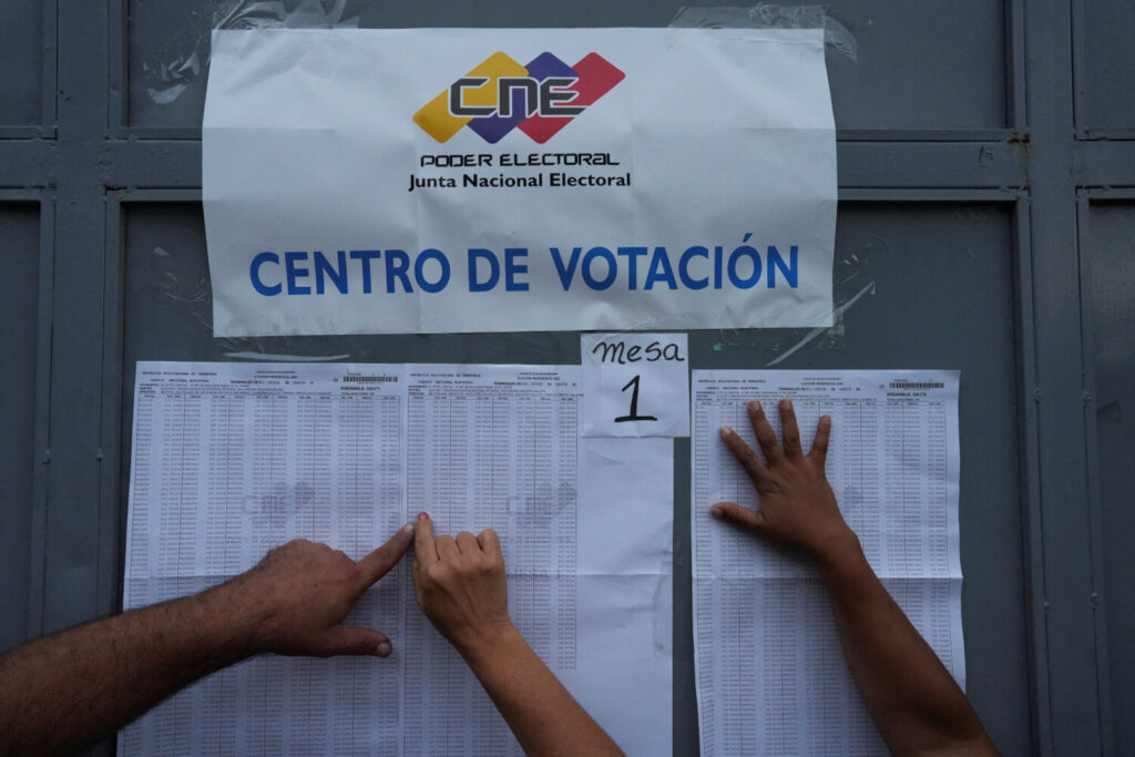 La gente comprueba la ubicación de sus casillas electorales durante las elecciones presidenciales del país, en Caracas, Venezuela, el 28 de julio de 2024. REUTERS/Alexandre Meneghini