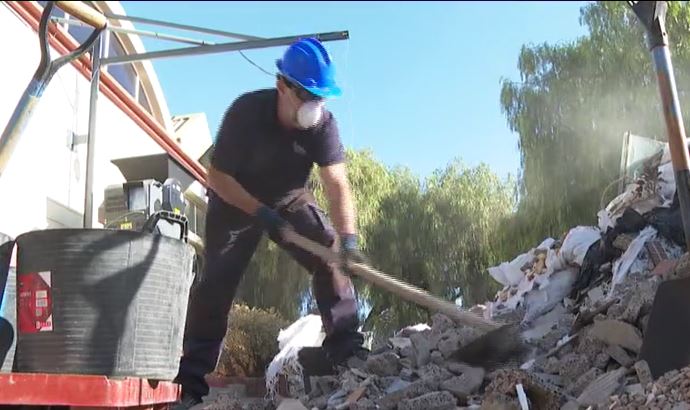 Obrero triturando material para hacer ladrillos reciclados