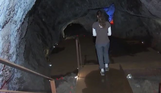 Una persona entrando dentro del tubo volcánico de la Cueva de Las Palomas