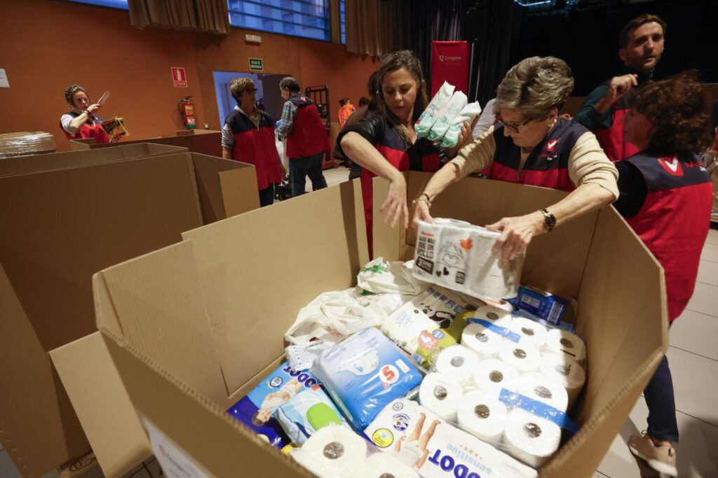 Voluntarios participan en la recogida de alimentos y demás enseres para las poblaciones valencianas afectadas por la dana, este lunes en un centro cívico de Zaragoza.