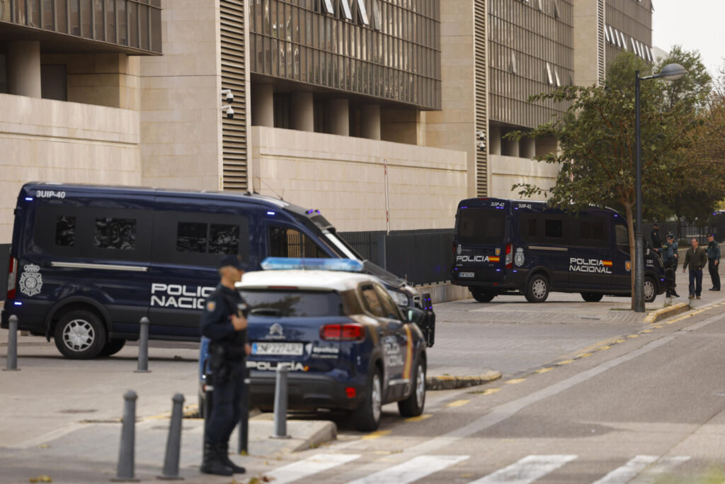 Varios agentes de la Policía Nacional aguardan junto a la Ciudad de la Justicia donde se encuentra el instituto de medicina legal