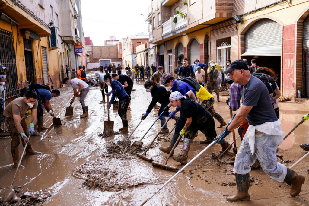 La gente limpia una calle embarrada tras las inundaciones causadas por las fuertes lluvias en Massanassa, Valencia, España, el 8 de noviembre de 2024. REUTERS/Ana Beltran