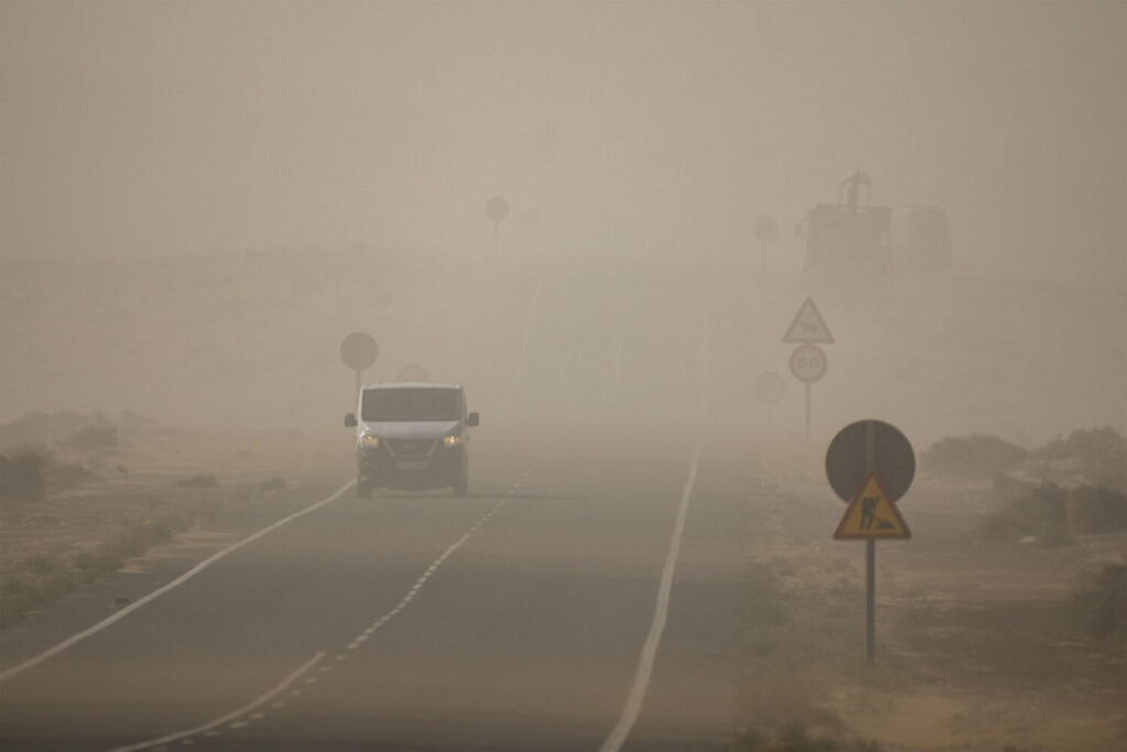 Una masa de aire cargada de polvo del Sahara envuelve Canarias tras el paso de la borrasca Dorothea, reduciendo la visibilidad en algunos casos por debajo de mil metros. En la imagen un coche circula por la carretera de Tiagua, en la isla de Lanzarote. EFE