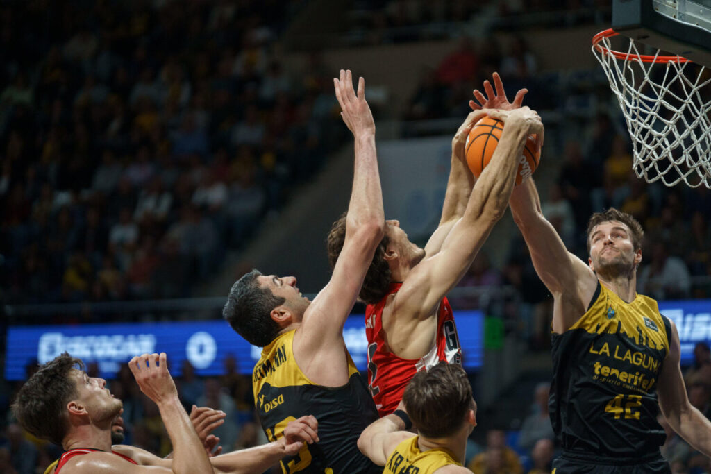 El pívot del Basquet Girona Francisco Cáffaro (c) y el pívot de La Laguna Tenerife Shermadini (i) durante el partido de la jornada 17 de la Liga Endesa que ambos equipos disputaron este sábado en el pabellón Santiago Martín de La Laguna